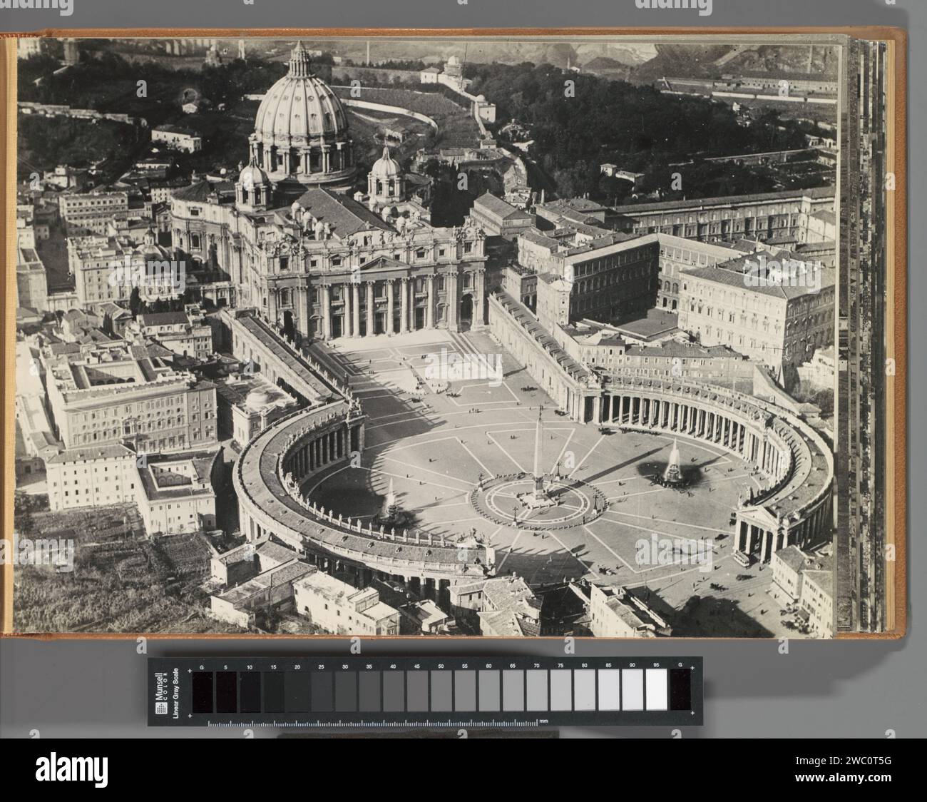 Sint-Pietersplein in Rom, aus der Luft gesehen, ca. 1930 - ca. 1940 Fotoalbum Magazin mit einem Foto von Sint-Pietersbasiliek, Sint-Pietersplein und umliegenden Gebäuden in Rom, einer der Stationen des KLM-Fluges Amsterdam-Batavia. Teil des Gedenkalbums der Indischen Linie von KLM, Teil I Saint Peters Square Paper. Unterstützung für Fotos. Pappe Gelatine Silberdruck Luftverkehr, Luftfahrt. Reisen; Tourismus. Aussicht auf die Stadt, Stadtpanorama, Silhouette des Petersplatzes Stockfoto