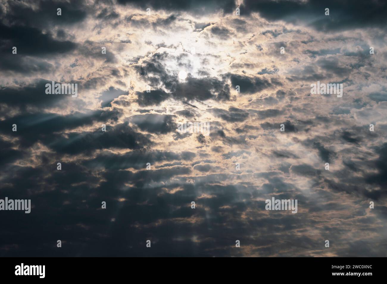 Die Sonne versucht, durch die Wolken zu brechen und so einen dramatischen Himmel in Namibia zu schaffen Stockfoto