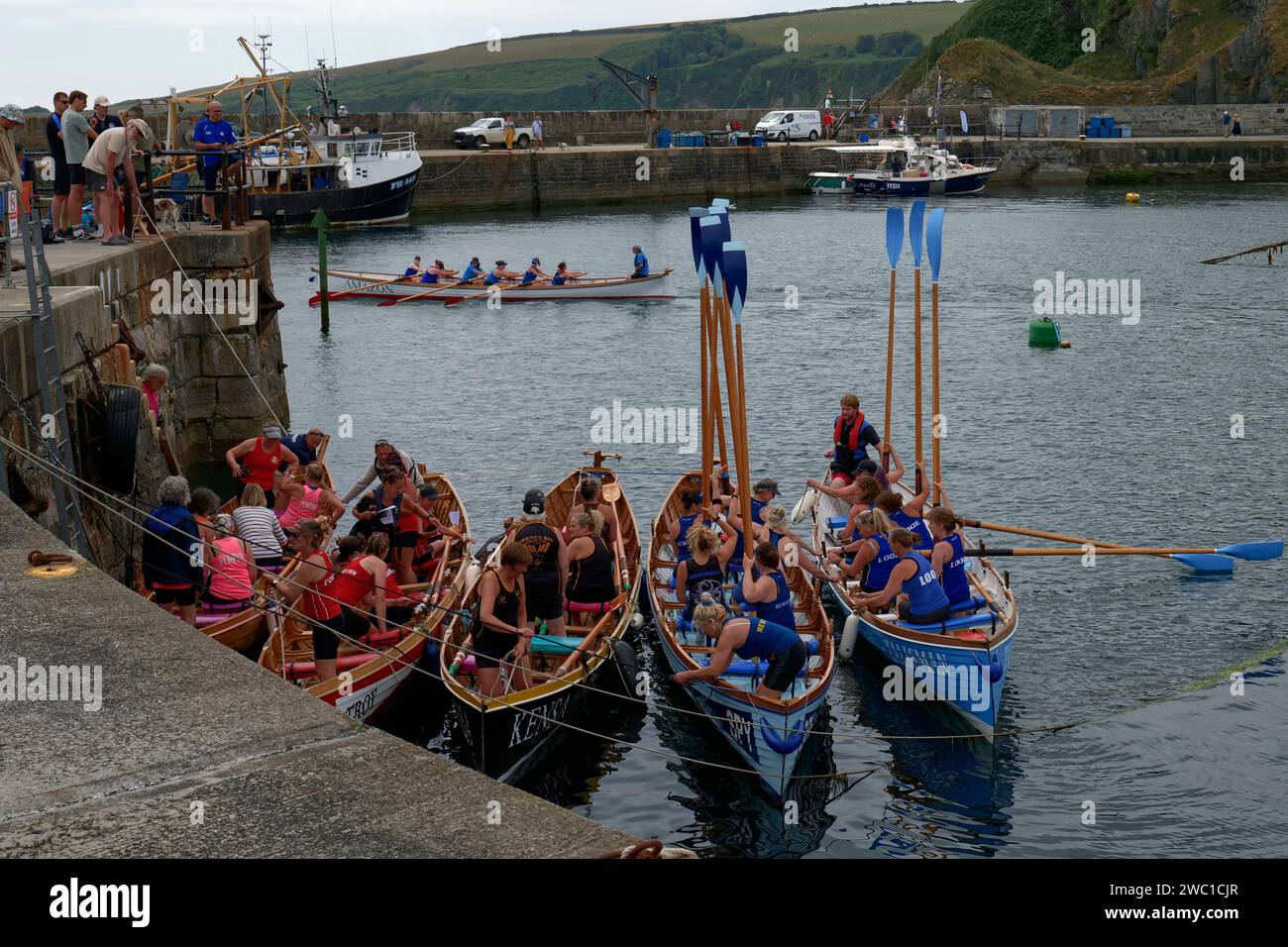 Die Crews machen sich auf ihre Boote für die Pilotenrennen der Damen auf der Regatta Mevagissey, Cornwall, England, Großbritannien bereit Stockfoto