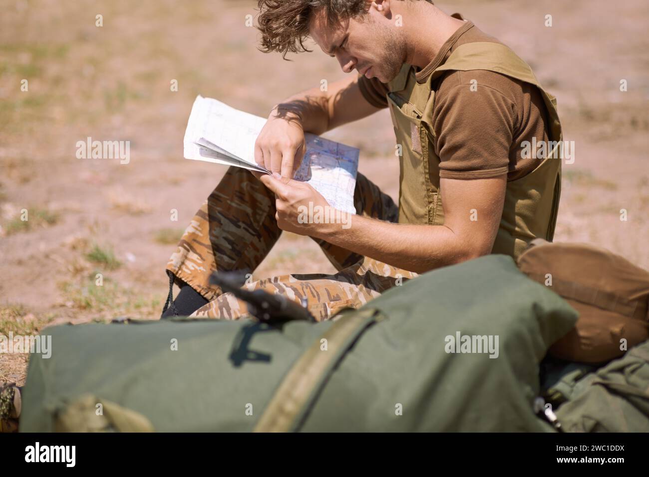 Mann mit Karte auf dem Schlachtfeld, Planung des Kampfortes oder taktische Einsatzziele für Kriegseinsätze. Der Soldat ist draußen im Militärstützlager, Check Stockfoto