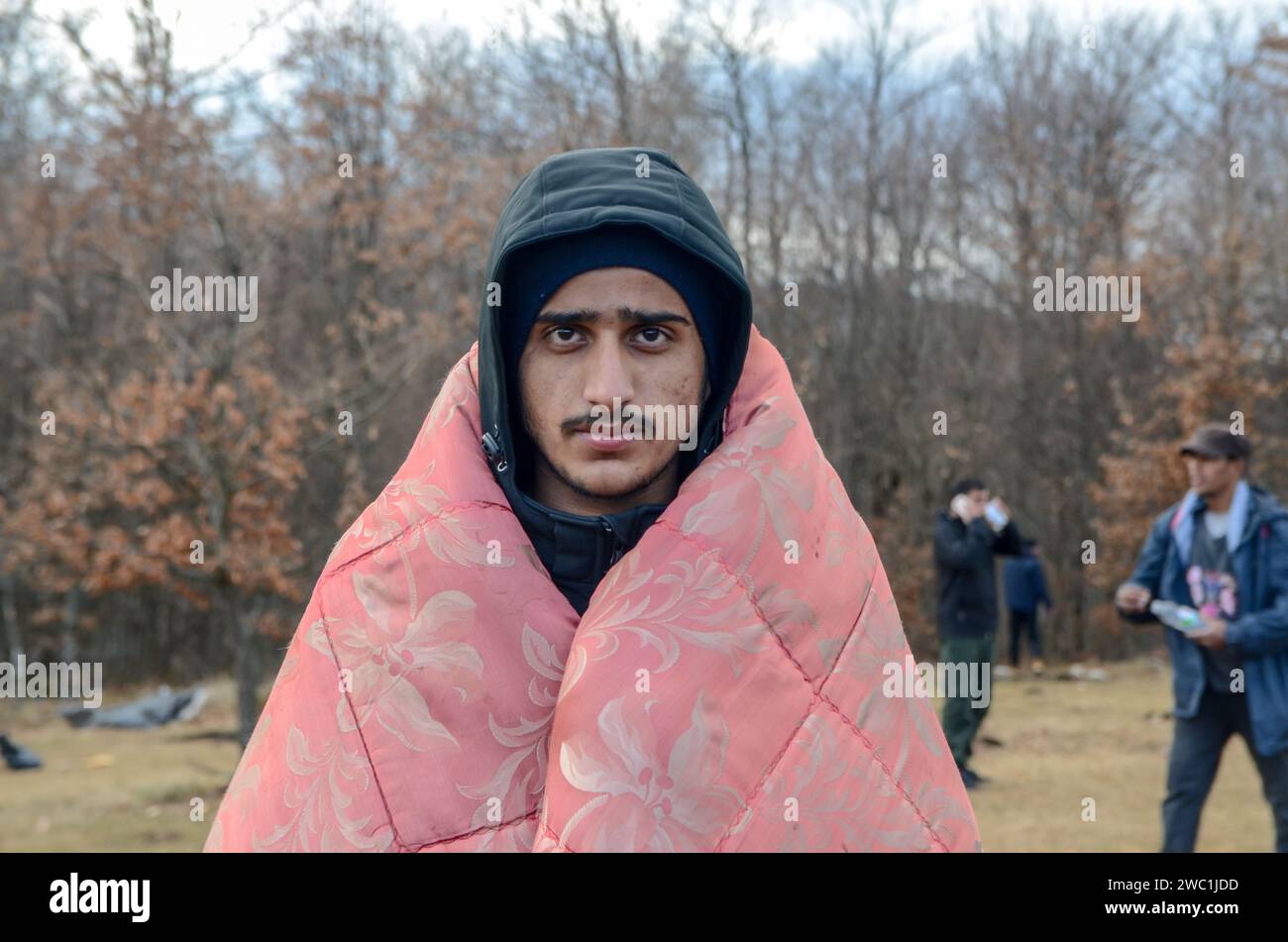 Gruppe von Flüchtlingen, die an kalten Wintertagen in der Nahrungslinie gefrieren. Hunderte Migranten frieren im Lager Lipa ein. Unmenschlicher Zustand. Balkanroute. Stockfoto