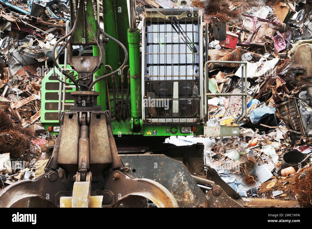 Ein Krankran steht vor einem zur Entsorgung bestimmten Metallabfall. Stockfoto