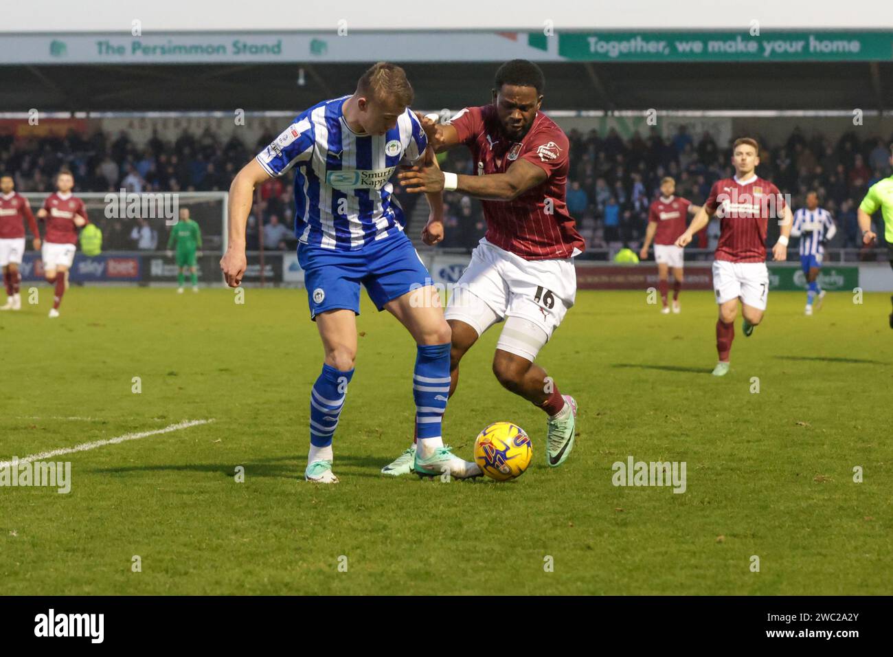 Der Tyreece Simpson von Northampton Town wird am Samstag, den 13. Januar 2024, im PTS Academy Stadium in Northampton in Northampton im zweiten Halbjahr des Spiels der Sky Bet League 1 zwischen Northampton Town und Wigan Athletic von Charlie Hughes bekämpft. (Foto: John Cripps | MI News) Credit: MI News & Sport /Alamy Live News Stockfoto