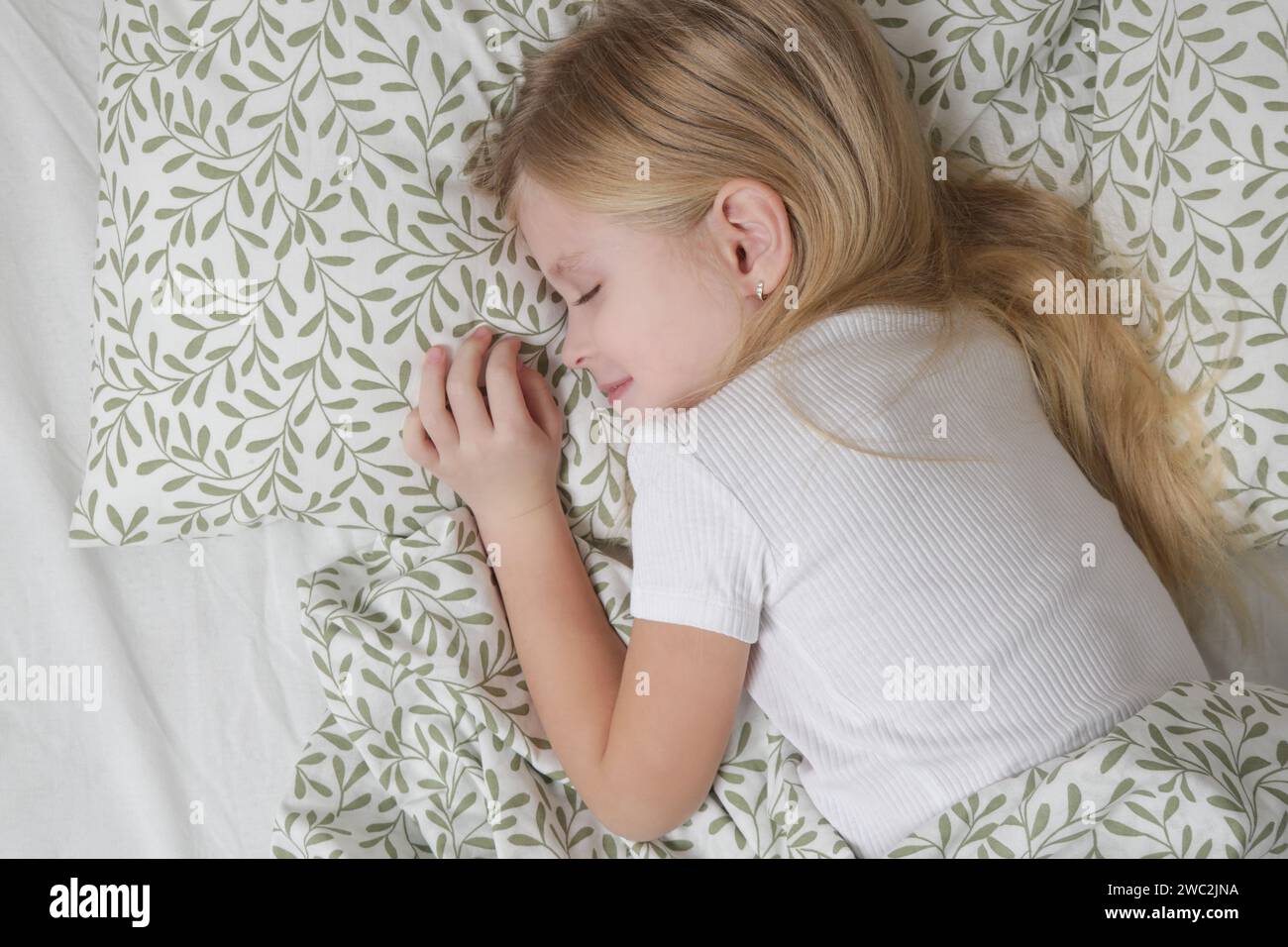 Süßes kleines Mädchen, das im Bett schläft Stockfoto