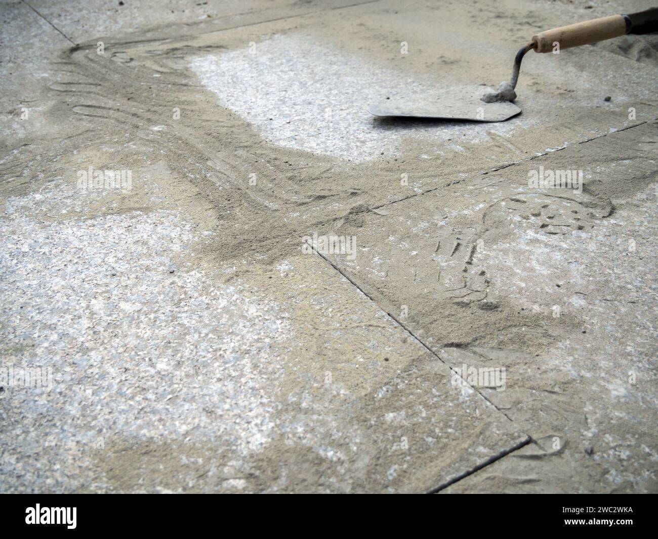 Hinterfüllung von Pflasterplatten mit Zement-Sand-Gemisch Stockfoto