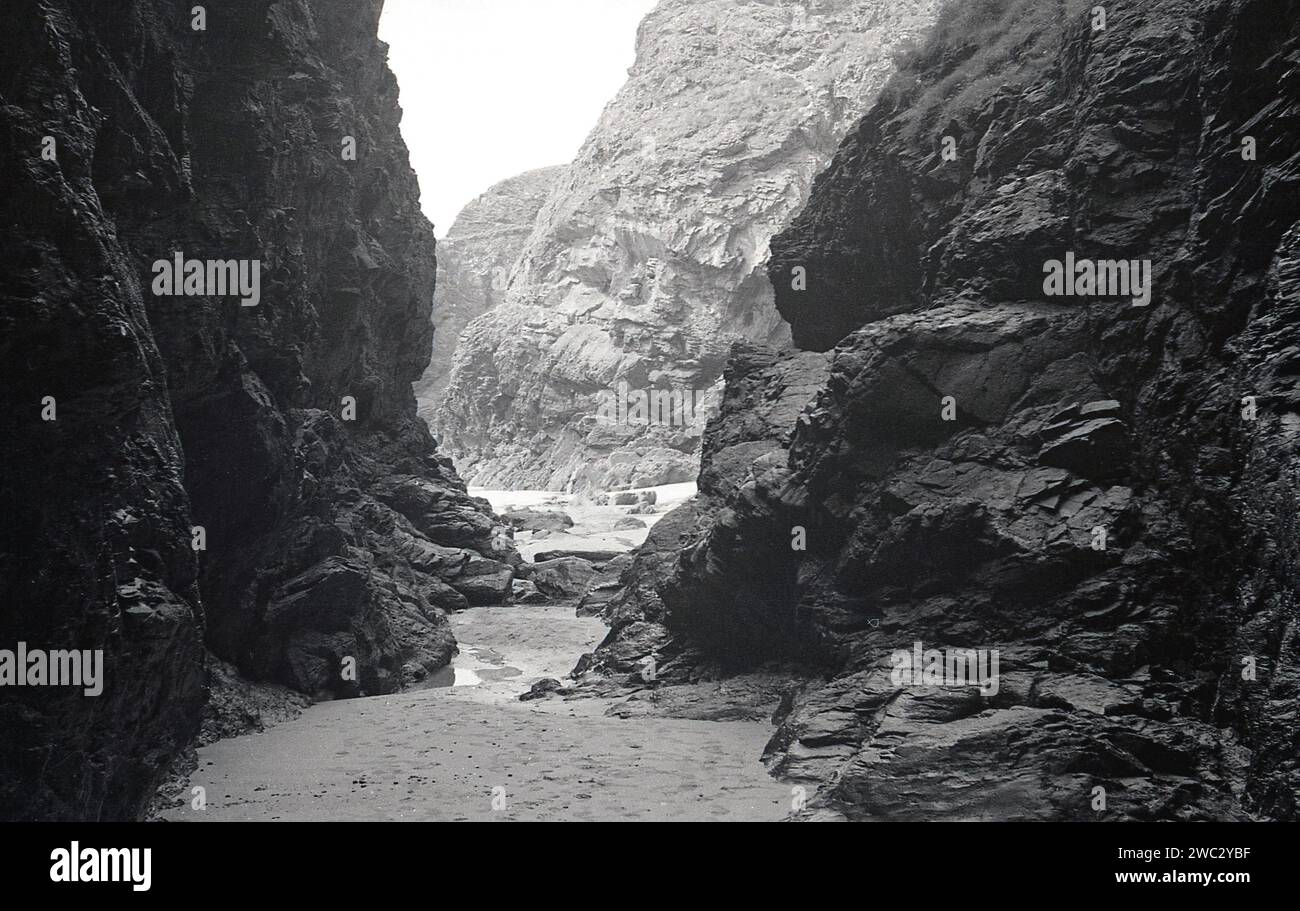 1960er Jahre, historische, große Granitfelsen an einer Bucht an der Küste cornwalls in der Nähe von Boscastle, Cornwall, England, Großbritannien. Der Westen von Cornwall ist berühmt für seine zerklüfteten Klippen und geschützten Buchten. Seine Geologie dominiert von seinen harten Felsen, die resistent gegen Erosion sind, hat seine dramatische Küste geschaffen. Stockfoto