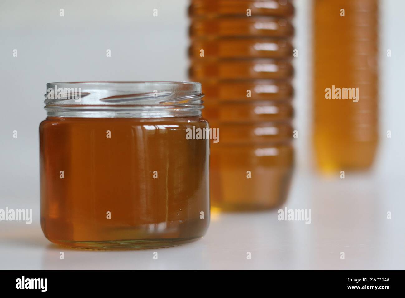 Goldener hausgemachter Honig, akribisch verarbeitet und wunderschön verpackt in PET- und Glasflaschen. Reine Süße erfasst, perfekt für natürliche, gesunde liv Stockfoto