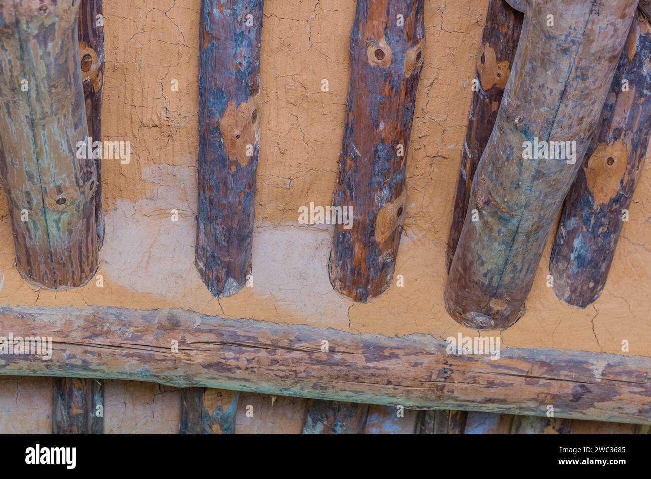 Nahaufnahme von Baumstämmen und Schlamm in der Decke der alten Blockhütte Stockfoto