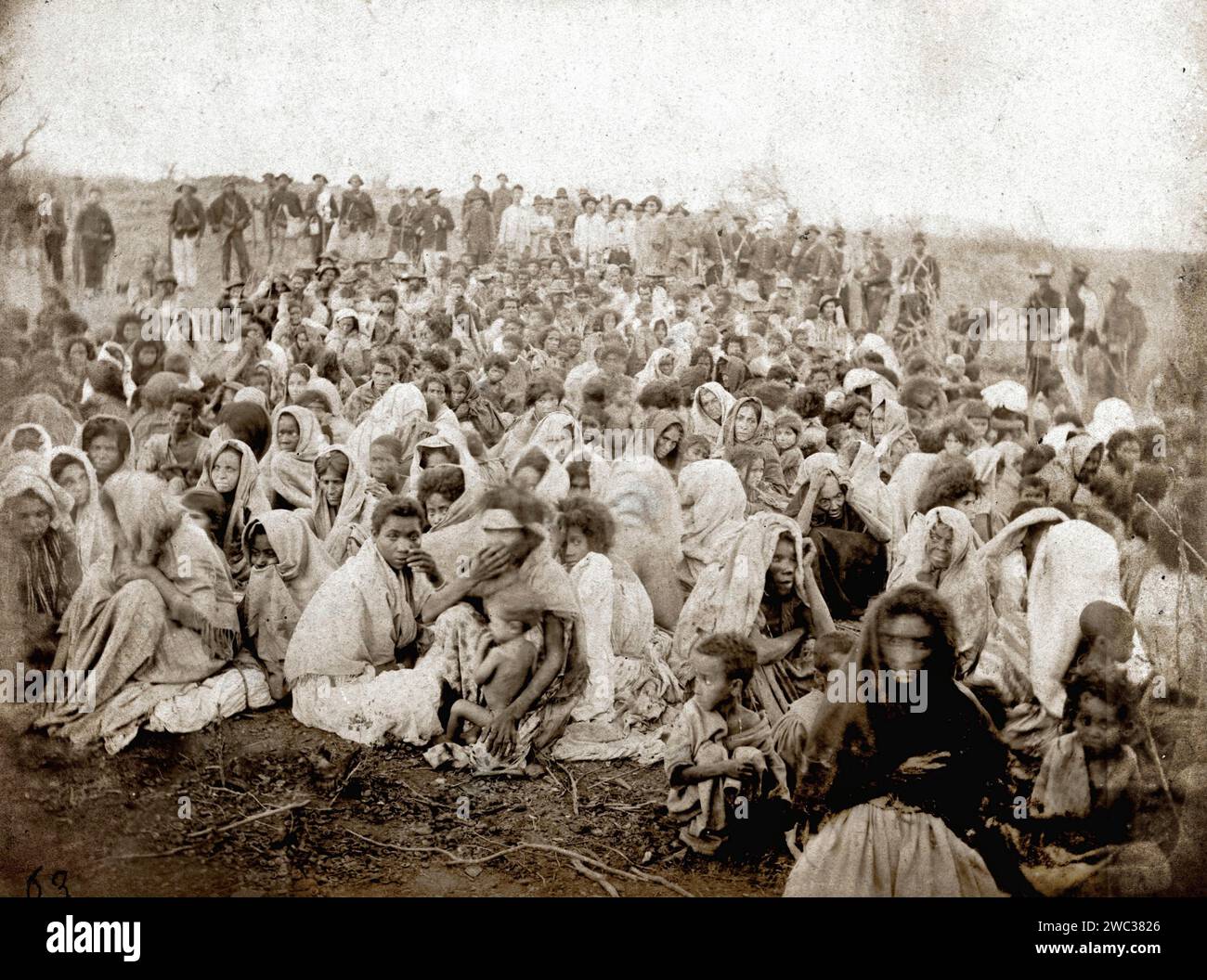 Titel: Überlebende des Krieges von Canudos 1897 Fotograf: Flavio de Barros Jahr: 1897 Medium: Fotografie Flavio de Barros nahm mit dem Foto „Überlebende des Krieges von Canudos“ 1897 einen ergreifenden Moment in der brasilianischen Geschichte ein. Dieses Bild dokumentiert die Folgen des Canudos-Krieges, der als der blutigste Bürgerkrieg in der Geschichte Brasiliens gilt. Die Gesichter der Überlebenden zeugen vom menschlichen Tribut dieses tragischen Ereignisses und bieten einen ernüchternden Einblick in die Folgen des Bürgerkriegs. Flavio de Barros' Objektiv liefert eine historische Aufzeichnung, die die Widerstandsfähigkeit und das Ende der Schwierigkeiten widerspiegelt Stockfoto