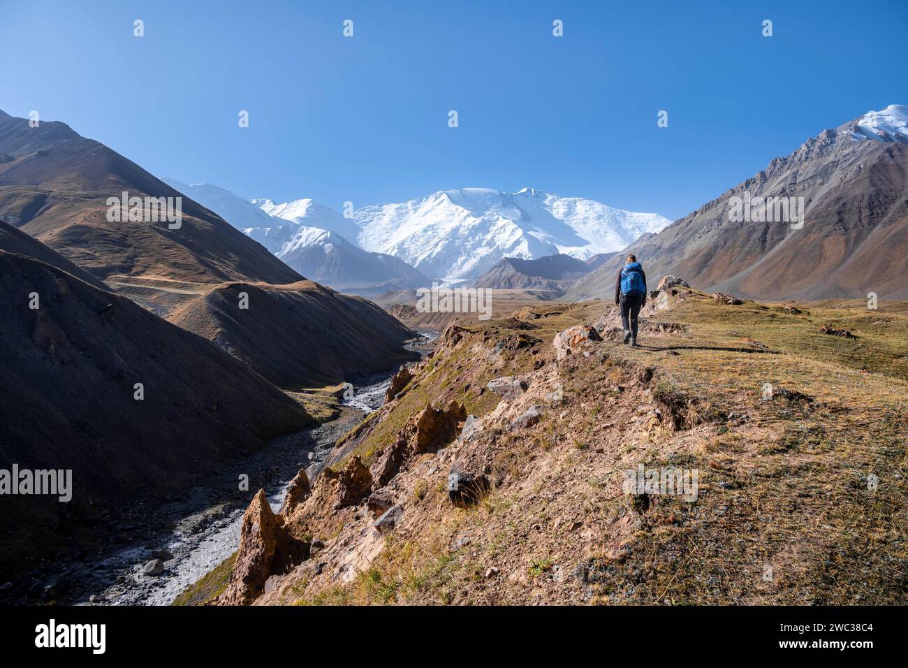 Wanderer im Tal mit dem Fluss Achik Tash zwischen hohen Bergen, Berglandschaft mit dem Gipfel Pik Lenin, Provinz Osh, Kirgisistan Stockfoto