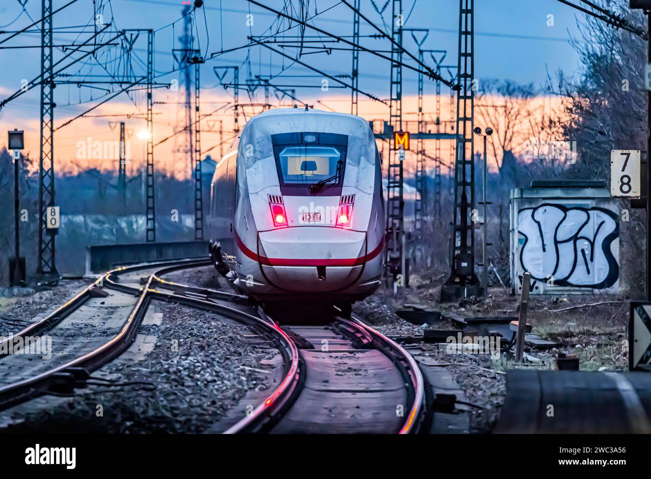 Bahnstrecke mit vielen Freileitungen und Bahnsignalen, InterCityExpress ICE der Deutschen Bahn AG, Rücklicht im Abendlicht, Stuttgart Stockfoto