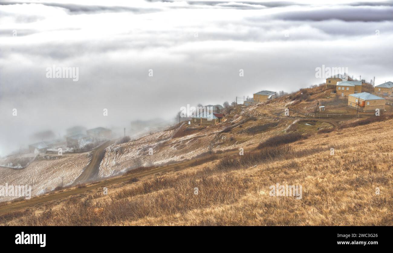 Blick von oben auf das von Wolken bedeckte Dorf Dagestan Stockfoto