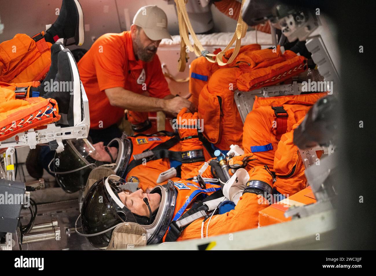Houston, Usa. Dezember 2023. Im Orion Mockup werden die Artemis II Mission Specialists Christina Koch von der NASA und Jeremy Hansen von der CSA während eines Notausstiegstrainings im Johnson Space Center am 8. Dezember 2023 in Houston, Texas, von einem Techniker überprüft. Quelle: James Blair/NASA/Alamy Live News Stockfoto