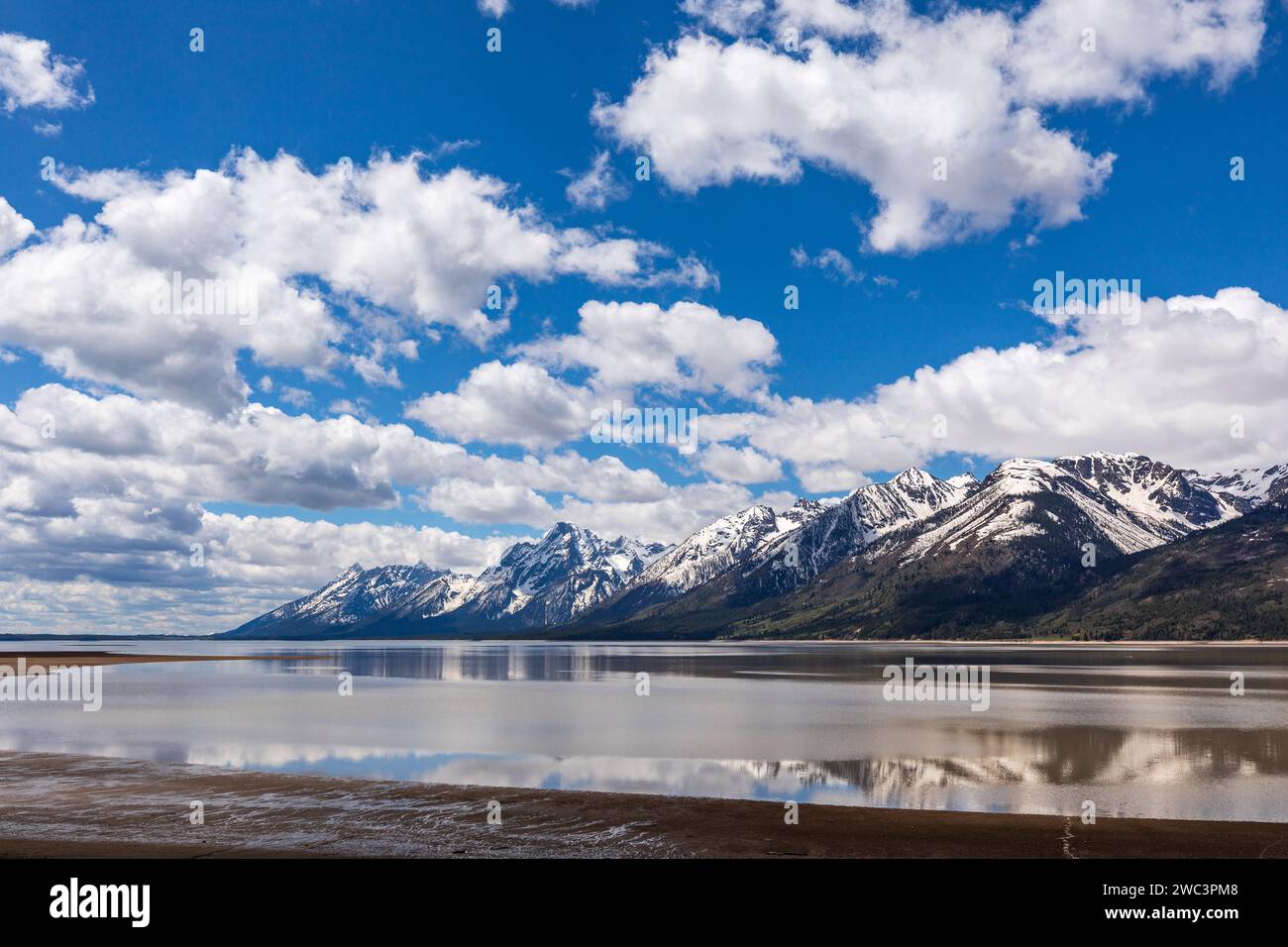 Blauer Himmel und schneebedeckte Berge spiegeln sich in den Gewässern eines glasklaren Sees Stockfoto