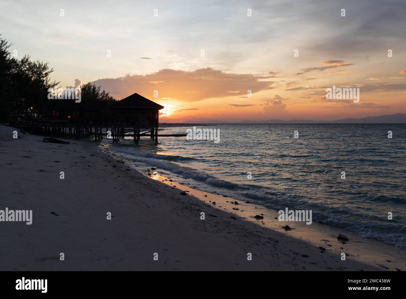 Sonnenaufgang Silhouetten ein Dock und Pavillon an einem wunderschönen tropischen Strand Stockfoto