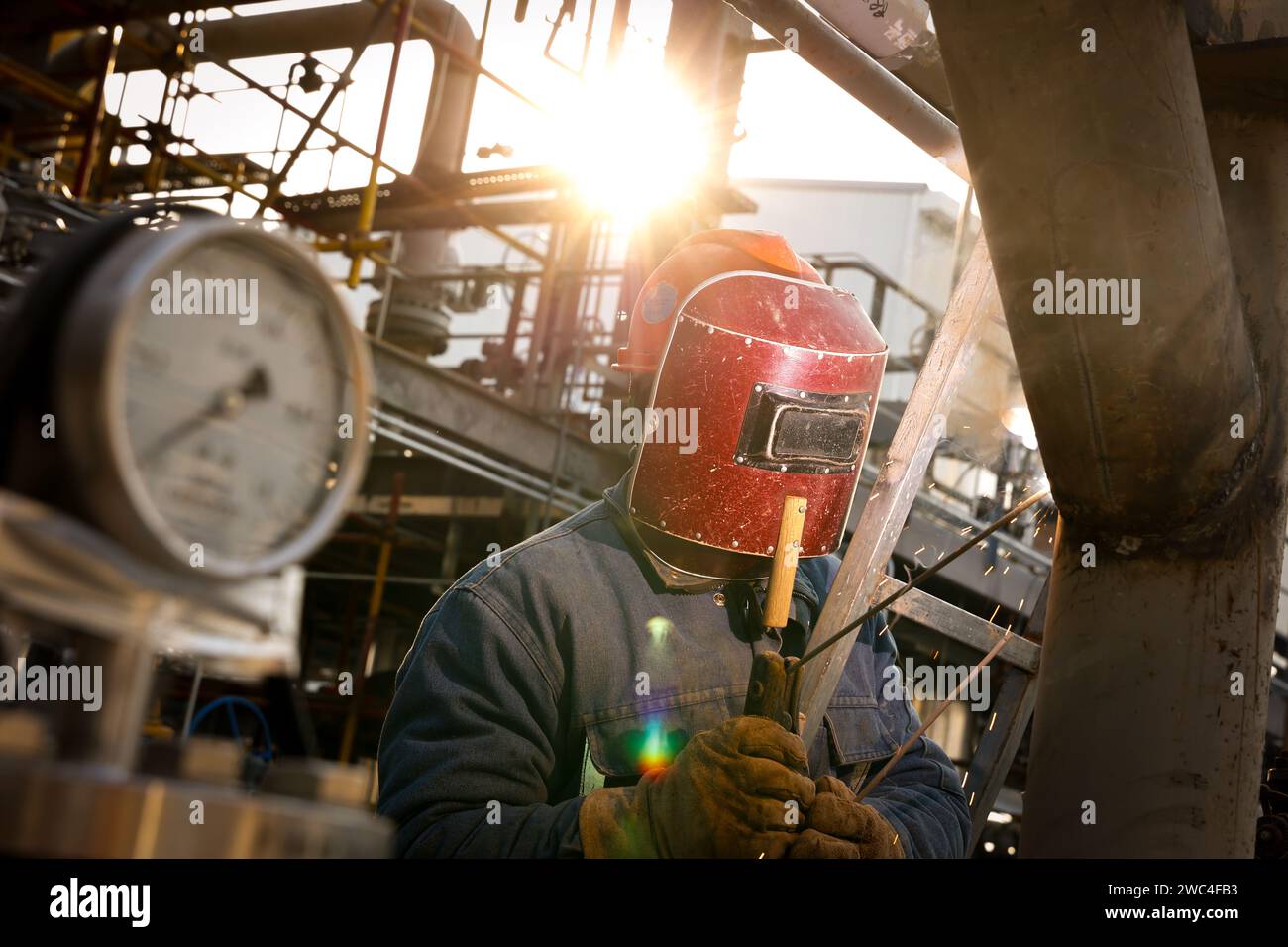 Peking, Chinas Provinz Shandong. Januar 2024. Ein Arbeiter schweißt auf der Baustelle eines Erdgasverarbeitungsterminalprojekts in Binzhou, ostchinesischer Provinz Shandong, 12. Januar 2024. Derzeit arbeiten fast 1.300 Arbeiter Tag und Nacht auf der Baustelle des Erdgasaufbereitungs-Terminals in Binzhou City, wobei der größte seiner Art von Bohai Oilfield, Chinas größtem Offshore-Erdölproduzenten, gebaut wird. Sie wird nach ihrer Fertigstellung zuverlässige grüne und saubere Energie für Nordchina liefern. Quelle: Du Penghui/Xinhua/Alamy Live News Stockfoto