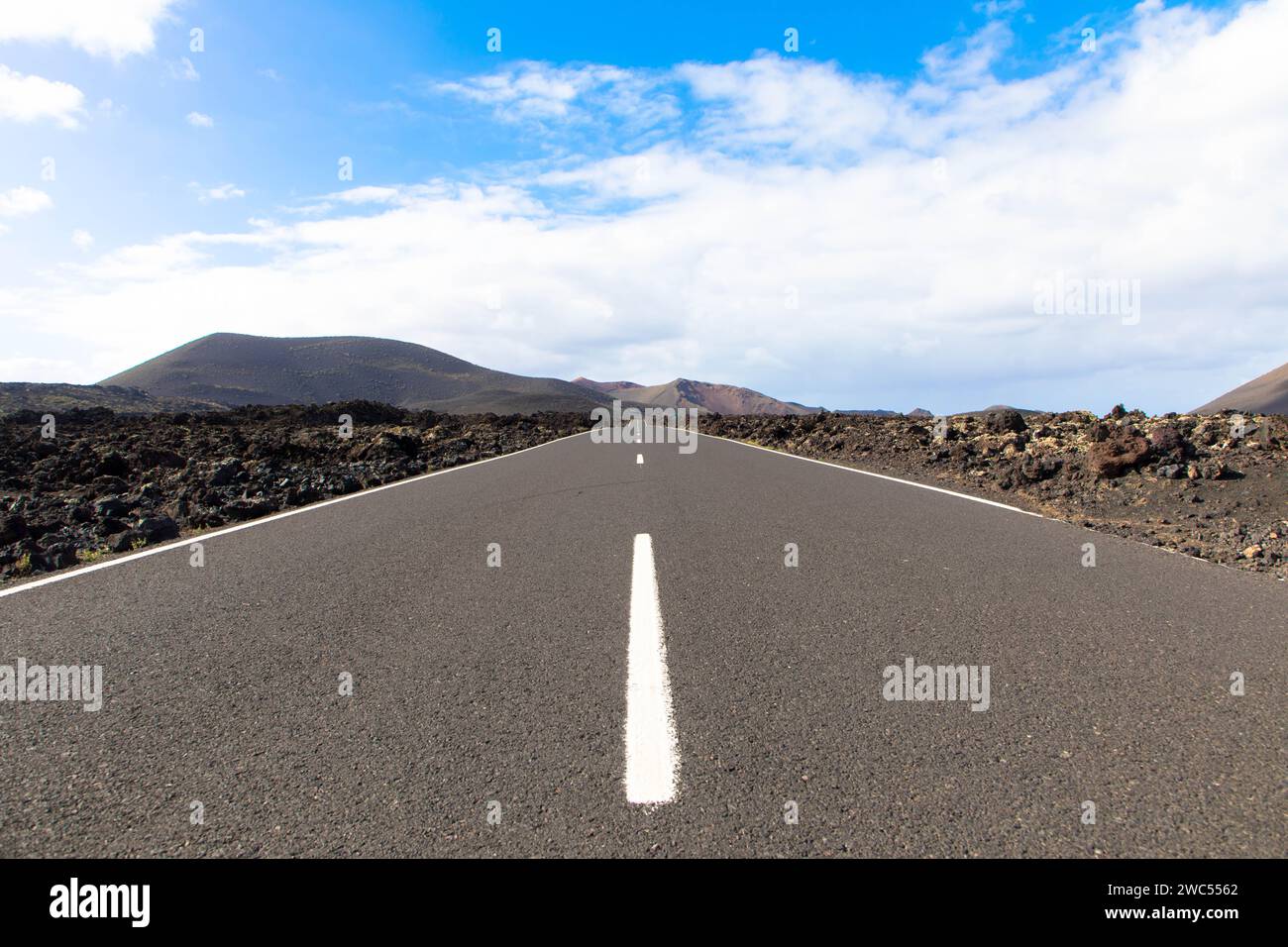 Panoramablick auf leere Asphaltstraße LZ-67 in vulkanischer Landschaft des Timanfaya Nationalparks, Lanzarote, Kanarische Inseln, Spanien, Europa Stockfoto