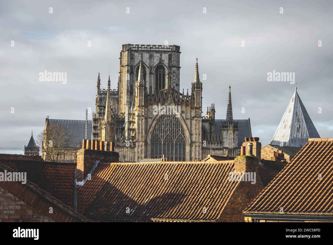 Blick auf das historische York Minster von den Dächern des Stadtzentrums von York, von den alten Stadtmauern aus gesehen. An einem bewölkten Tag mit Sonne. Stockfoto