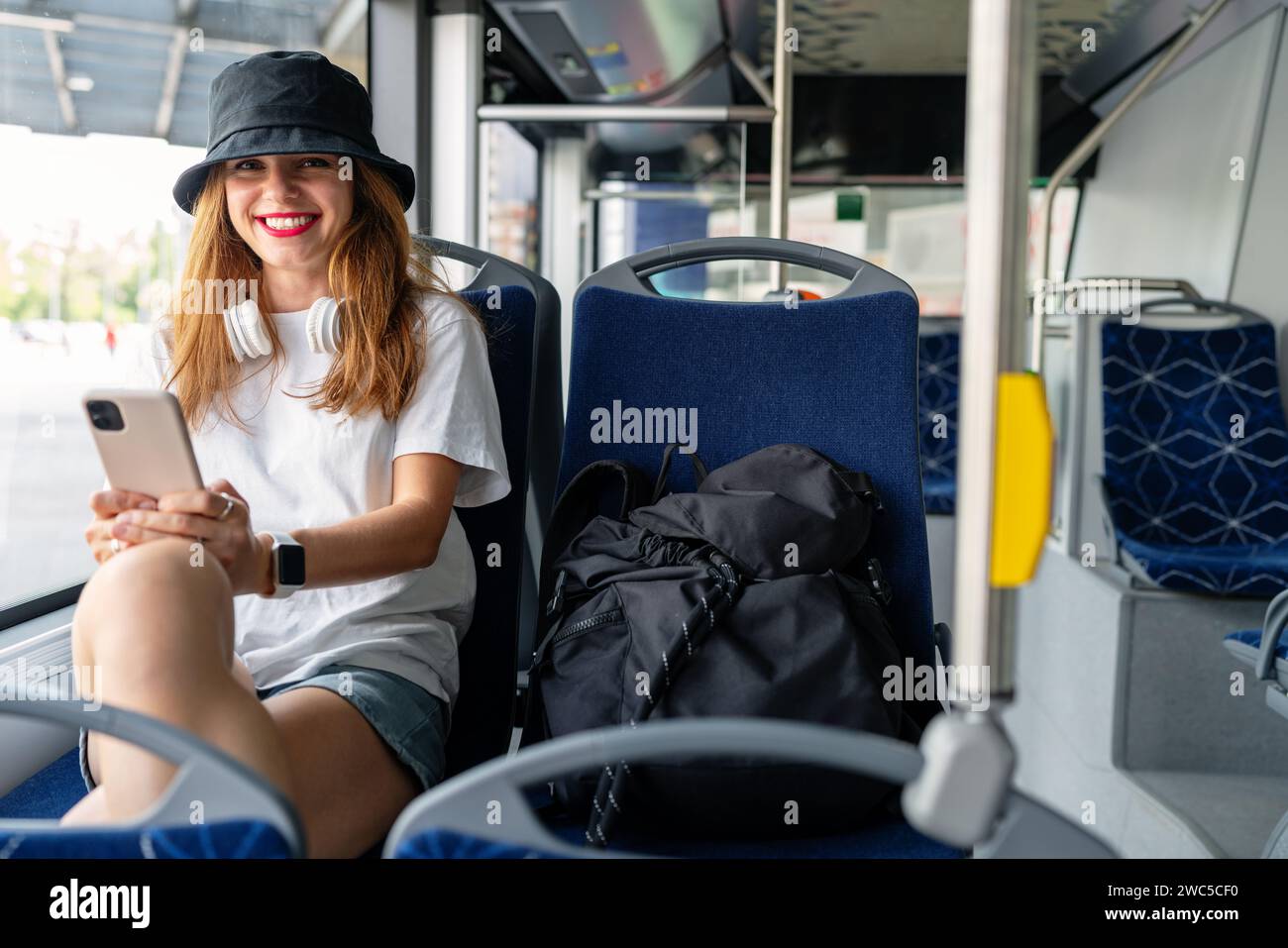 Eine junge, stilvolle Frau fährt mit dem Stadtbus. Stockfoto