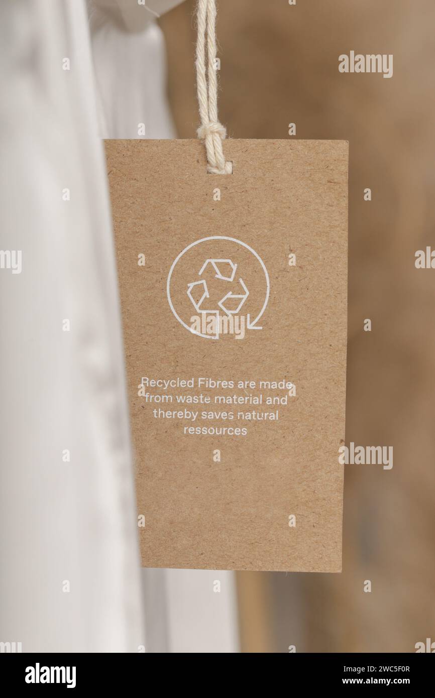 Nahaufnahme des Kleidungsanhängers mit Recycling-Symbol. Konzept des Recyclings von Produkten. Konzept für Abfallvermeidung, Suistainale-Produktion, Umweltpflege und Wiederverwendung. Stockfoto