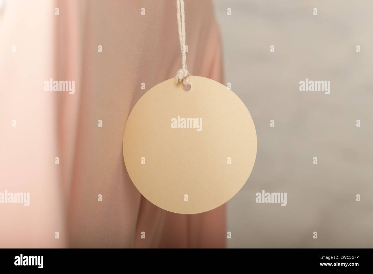 Nahaufnahme des Preises des Kleidungsstücks. Leeres Modell mit rundem Etikett auf einer Kleidung. Modeindustrie und Einzelhandelskonzept. Stockfoto