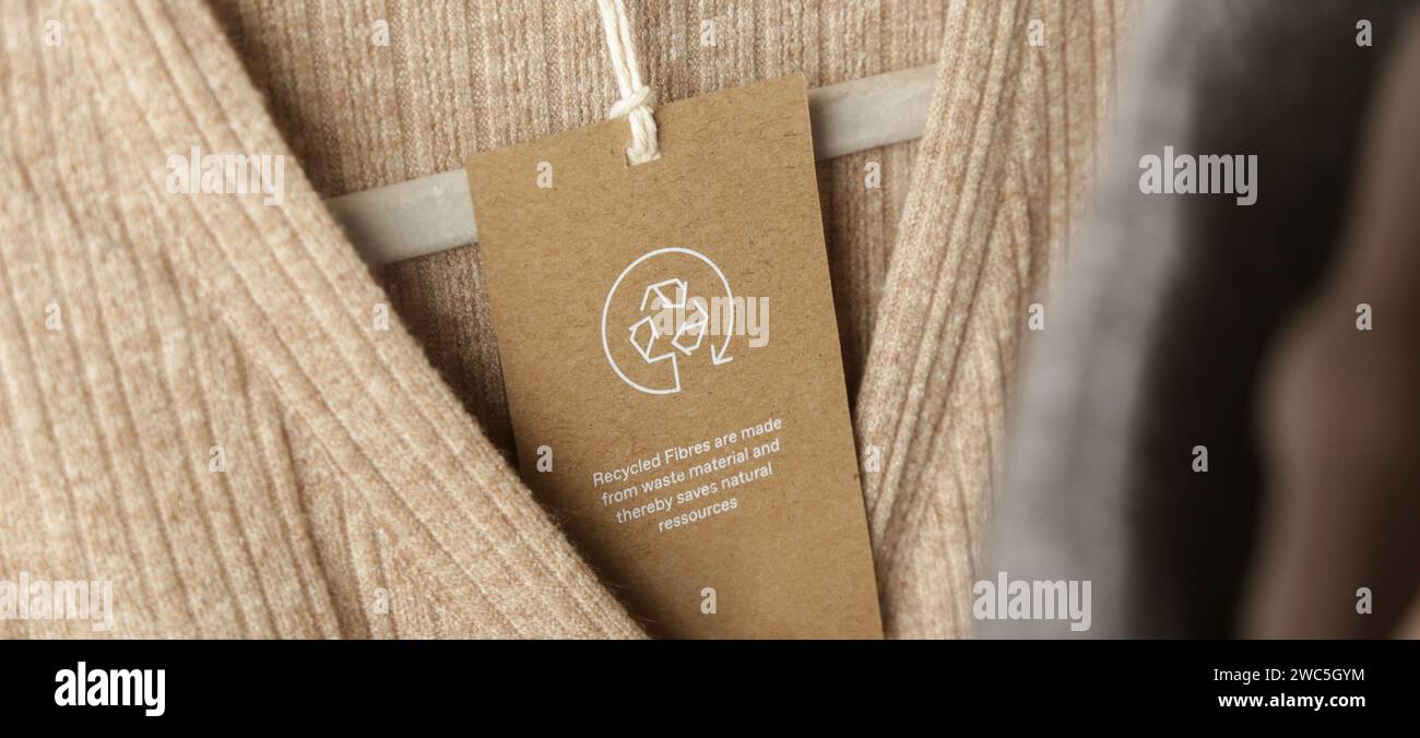 Nahaufnahme des Kleidungsanhängers mit Recycling-Symbol. Konzept des Recyclings von Produkten. Konzept für Abfallvermeidung, Suistainale-Produktion, Umweltpflege und Wiederverwendung. Stockfoto