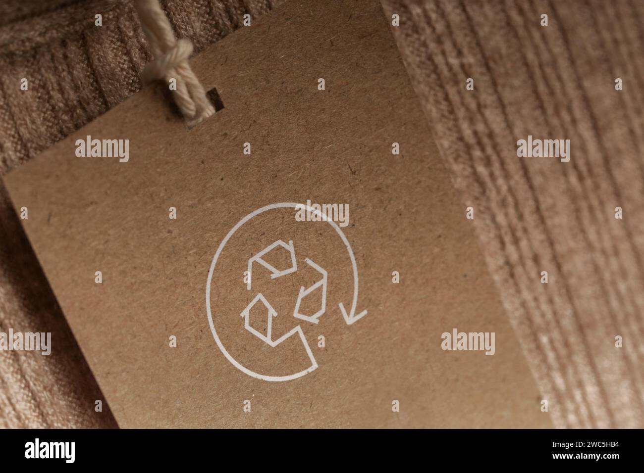 Nahaufnahme des Kleidungsanhängers mit Recycling-Symbol. Konzept des Recyclings von Produkten. Konzept für Abfallvermeidung, Suistainale-Produktion, Umweltpflege und Wiederverwendung. Stockfoto