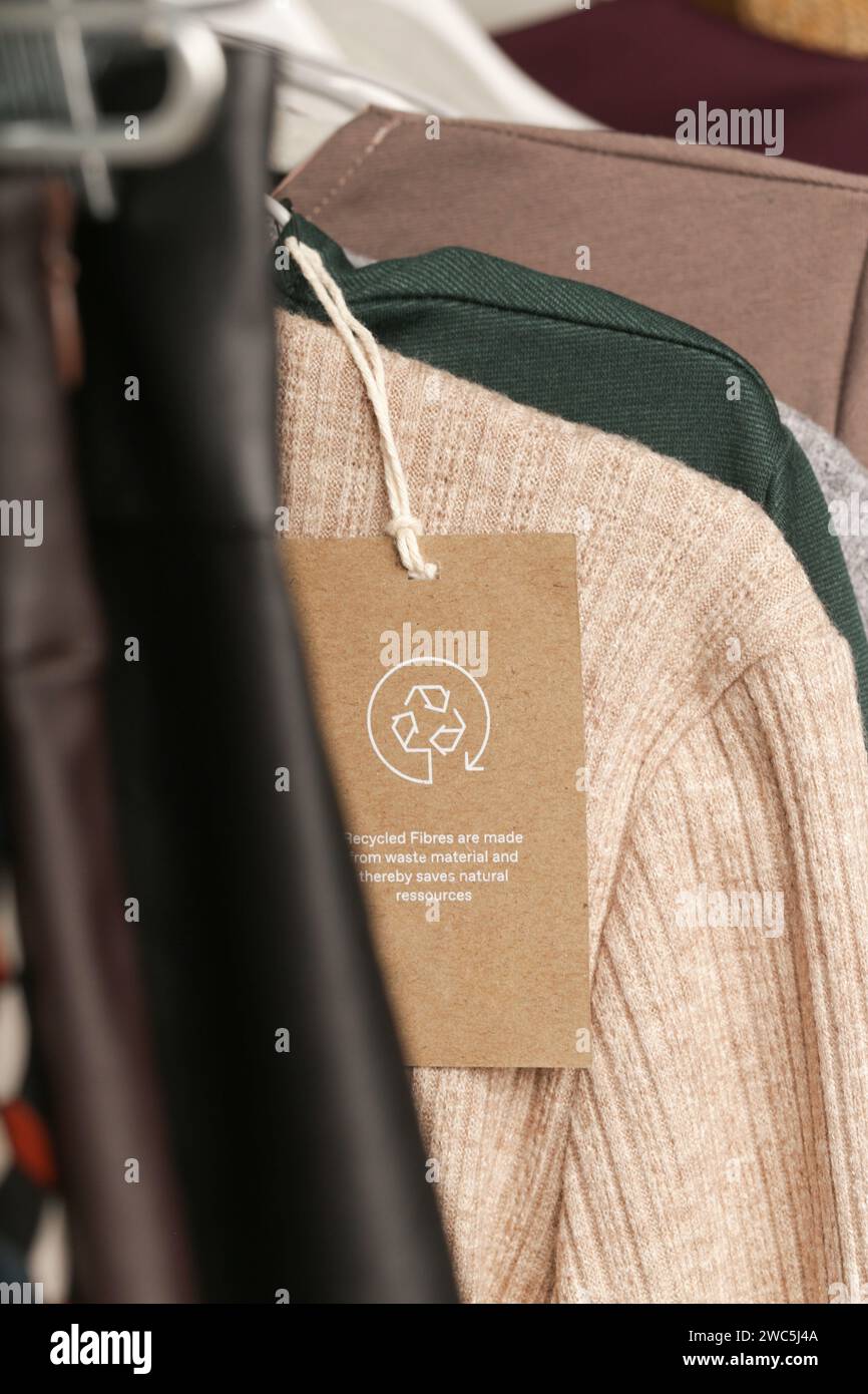 Nahaufnahme des Kleidungsanhängers mit Recycling-Symbol. Konzept des Recyclings von Produkten. Konzept für Abfallvermeidung, Suistainale-Produktion, Umweltpflege und Wiederverwendung. Stockfoto