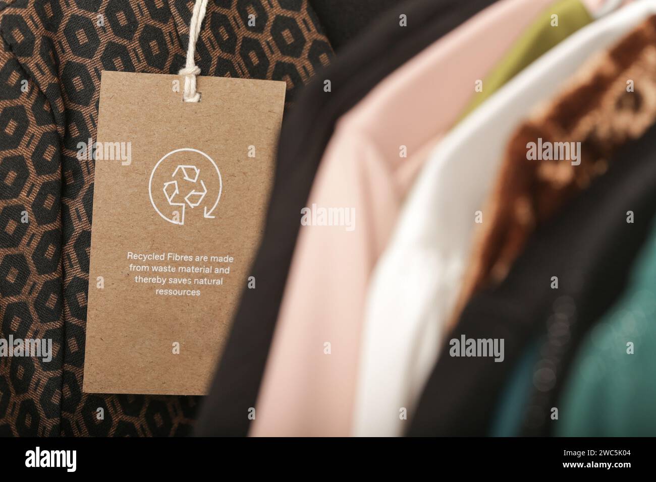 Nahaufnahme des Kleidungsanhängers mit Recycling-Symbol. Konzept des Recyclings von Produkten. Konzept für Abfallvermeidung, Suistainale-Produktion, Umweltpflege und Wiederverwendung. Stockfoto