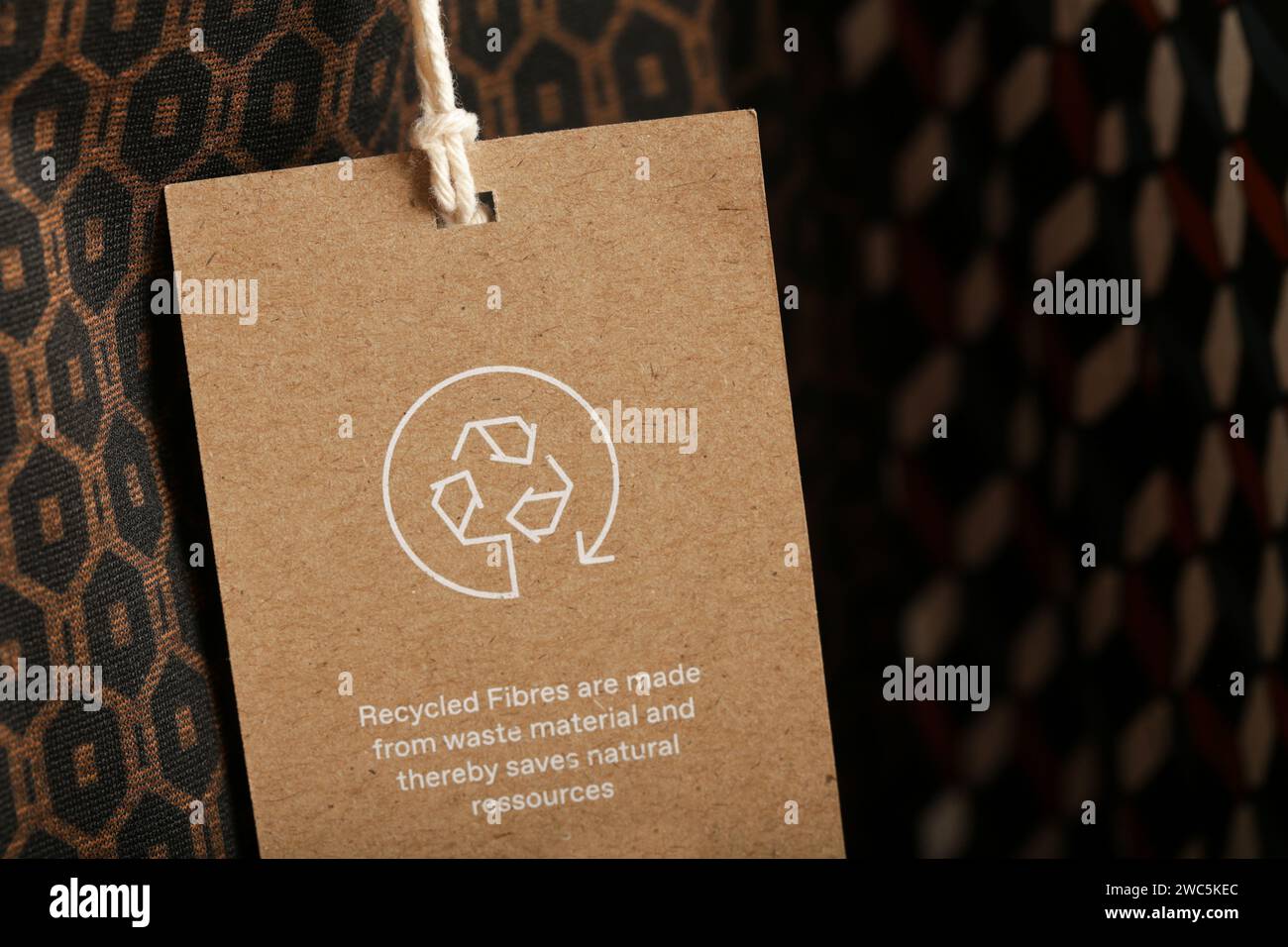 Nahaufnahme des Kleidungsanhängers mit Recycling-Symbol. Konzept des Recyclings von Produkten. Konzept für Abfallvermeidung, Suistainale-Produktion, Umweltpflege und Wiederverwendung. Stockfoto