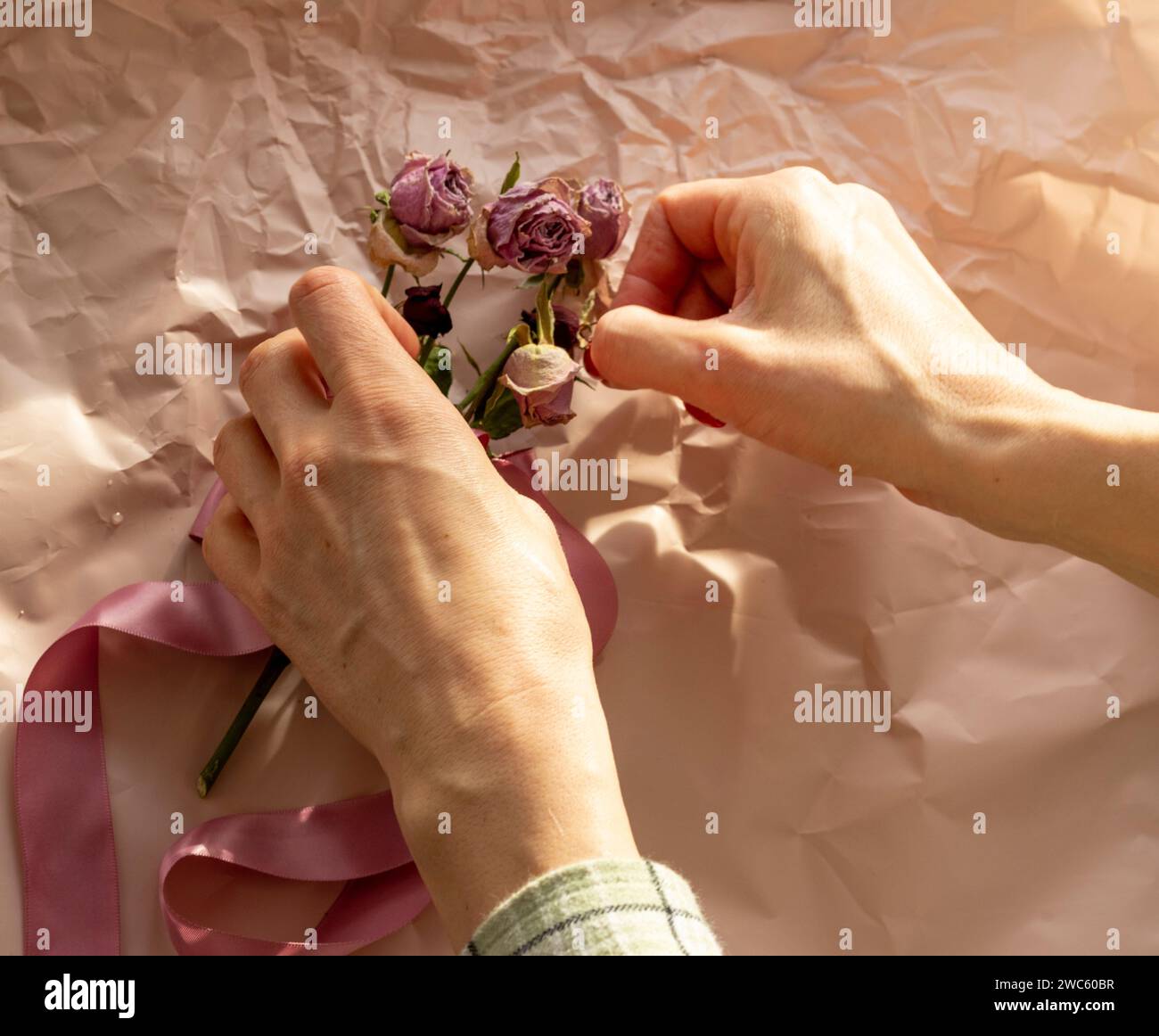 Konzeptaufnahme des Hintergrundthemas, Geschenkpapier, getrocknete Rosen, Blumen und andere Gestecke. Stockfoto