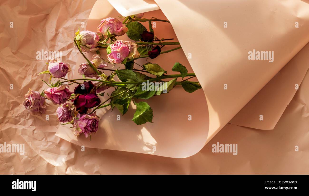 Konzeptaufnahme des Hintergrundthemas, Geschenkpapier, getrocknete Rosen, Blumen und andere Gestecke. Stockfoto