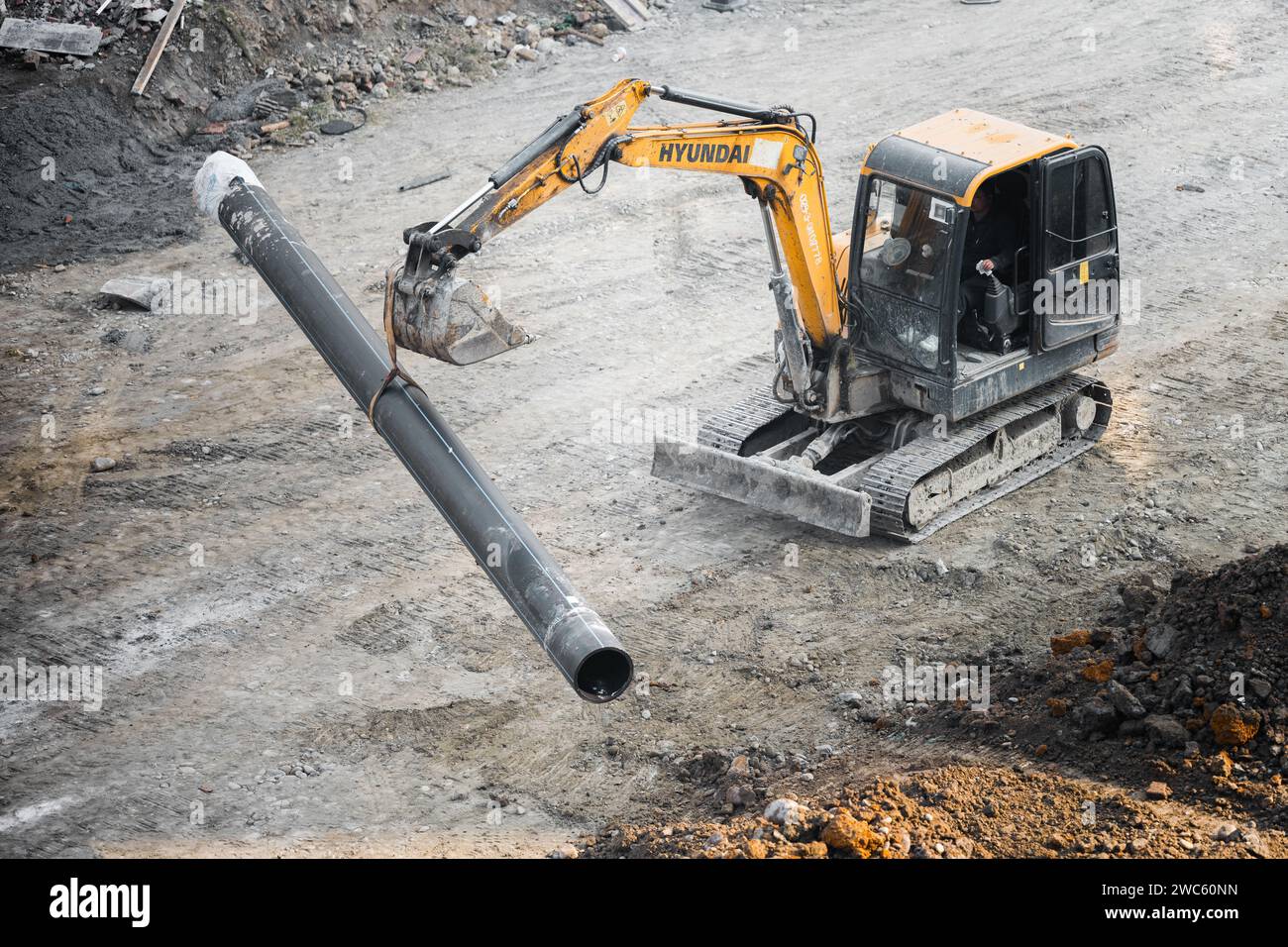 Der Bagger gräbt und transportiert am frühen Morgen Gegenstände Stockfoto