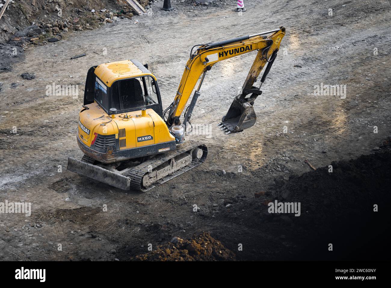 Der Bagger gräbt und transportiert am frühen Morgen Gegenstände Stockfoto