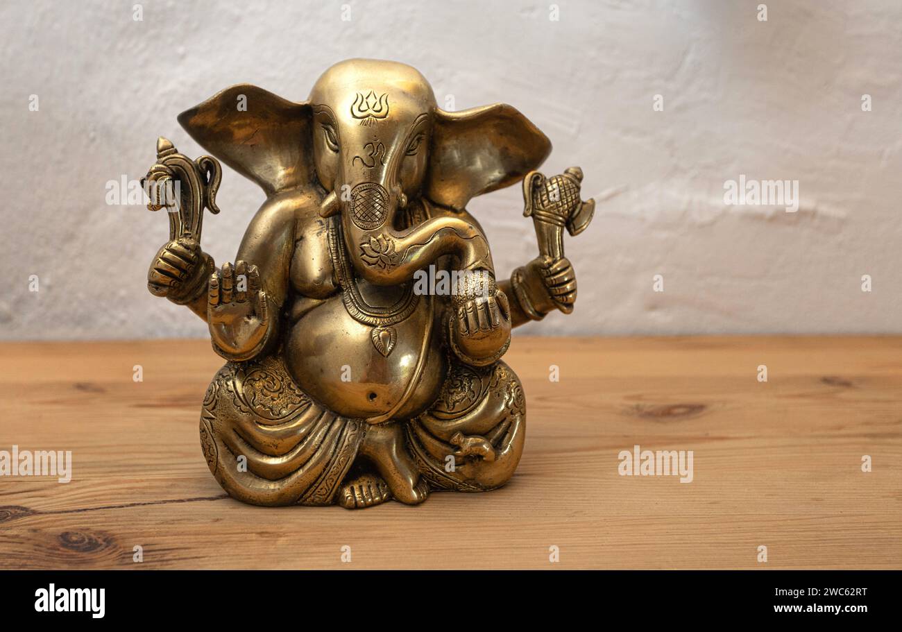 Ganesha – indischer Gott der Weisheit und des Wohlstands auf hölzernem Hintergrund. Stockfoto
