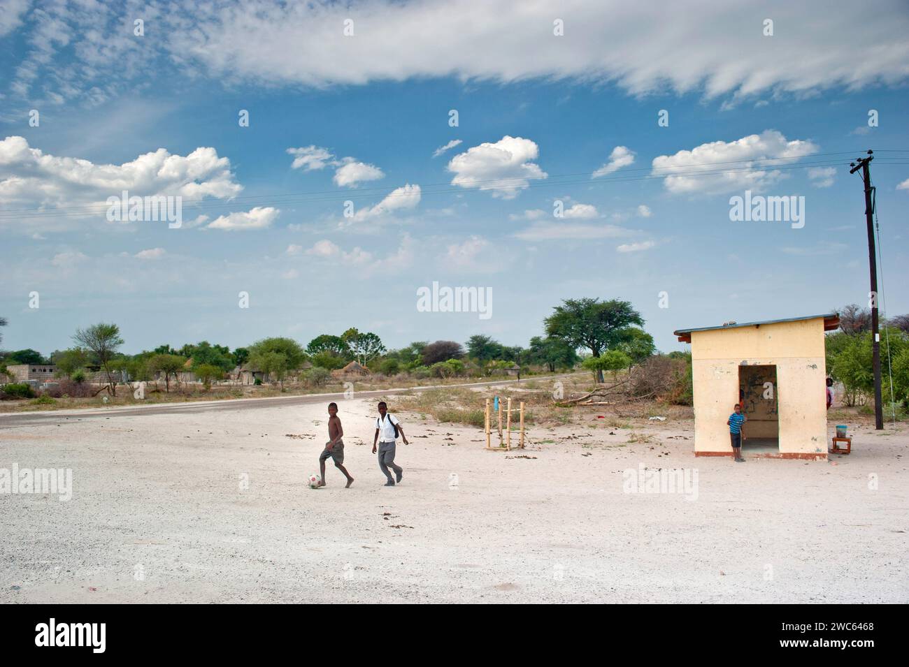 Kleine Dorfsiedlung mit Fußball spielenden Kindern, Dorf, Kinder, Dorf, Straße, Street Football, Freizeit, in der Nähe von Guamare in Botswana Stockfoto