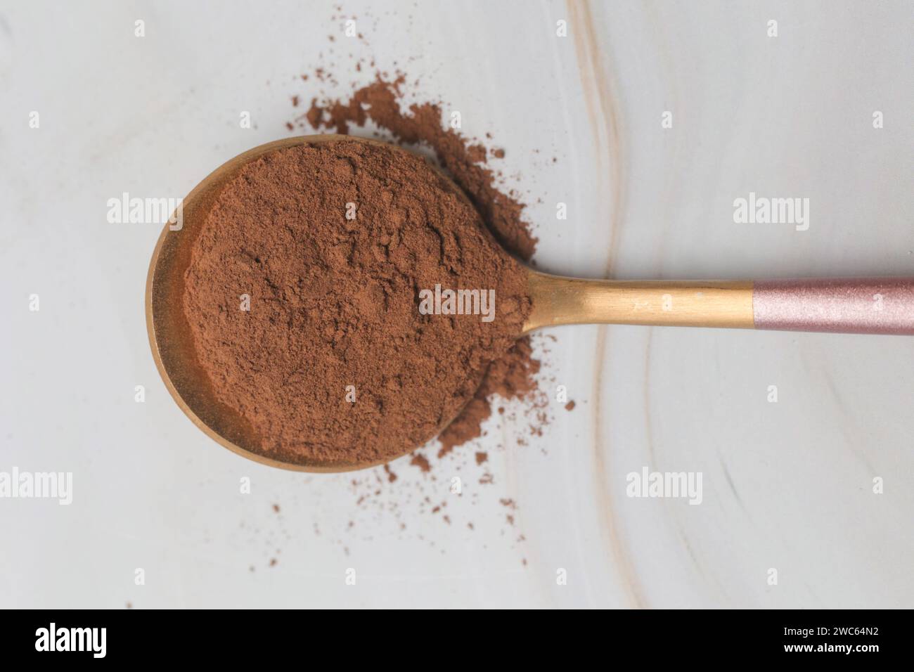 Ungesüßtes Kakaopulver aus dunkler Schokolade im Löffel Stockfoto