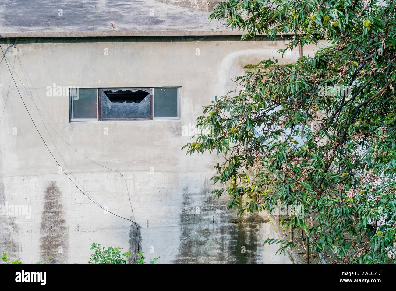 Kaputtes Fenster in der Außenwand des Gebäudes Stockfoto