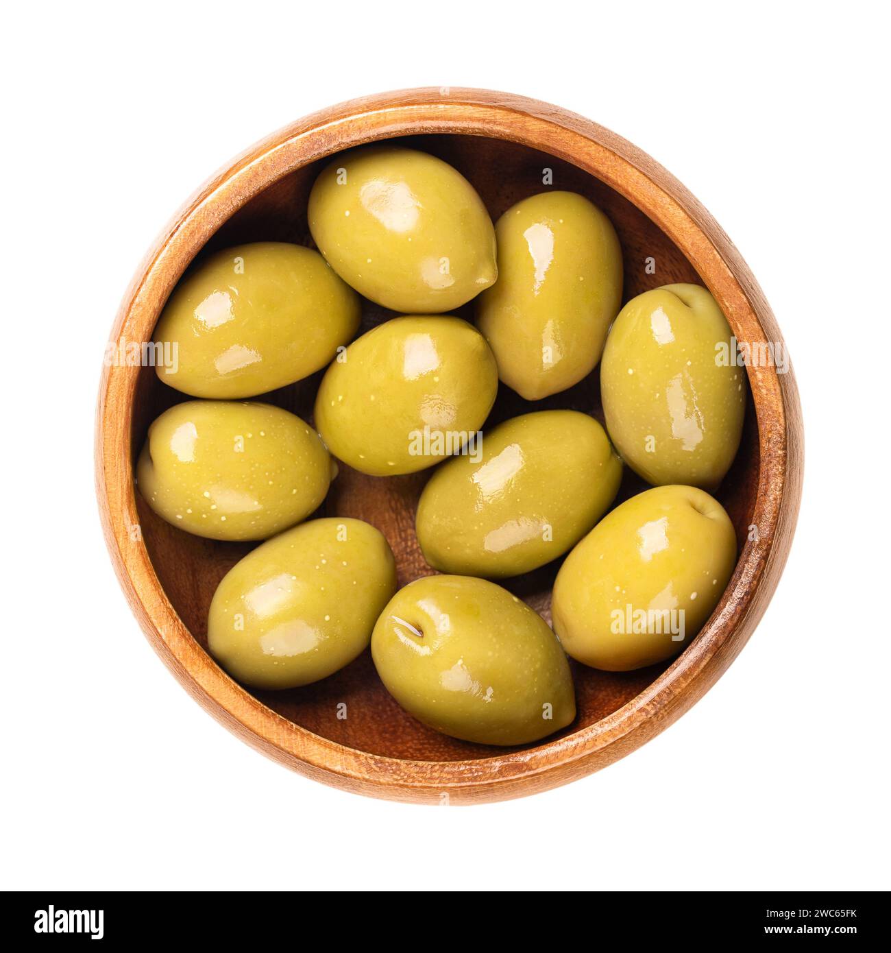 Grüne Oliven mit Grube, ganz eingelegt, große griechische Tafeloliven, in einer Holzschale. Ganze Früchte, wenn sie noch unreif sind und von bitterem Geschmack sind. Stockfoto