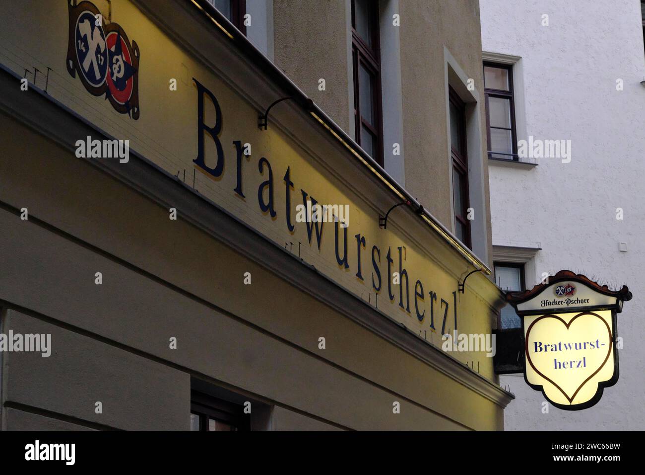Beleuchtetes Schild des traditionellen Restaurants Bratwurstherzl am Viktualienmarkt, München, Bayern, Deutschland Stockfoto