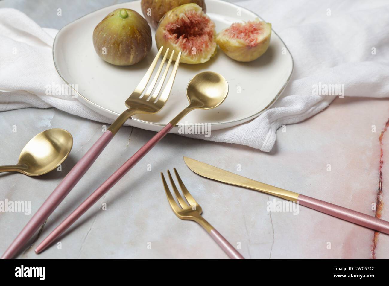 Kreative Aufnahme von goldenem Besteck auf Marmortisch, Designkonzept. Moderne Küche. Geschirr im skandinavischen Stil. Stockfoto
