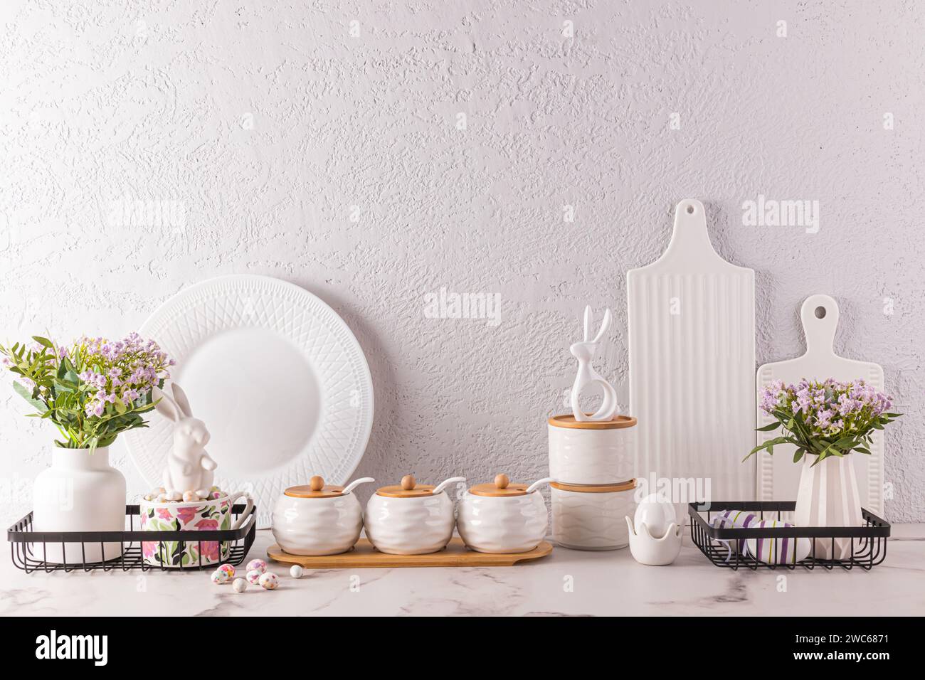 Stilvoller Küchen-Hintergrund für Osterferien mit traditionellen Symbolen und weißem Geschirr. Vordergrund. Osterferienkonzept Stockfoto