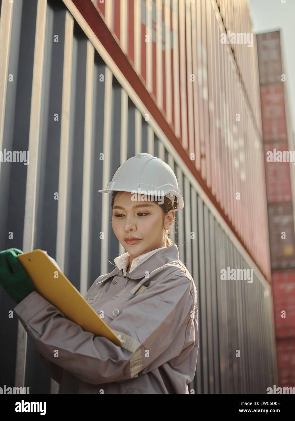 Asiatische Ingenieurin, die im Containerhafen-Terminal arbeitet. Bearbeitung von Aufträgen und Produkten im Lagerlogistik in Fracht für den Import Export Stockfoto