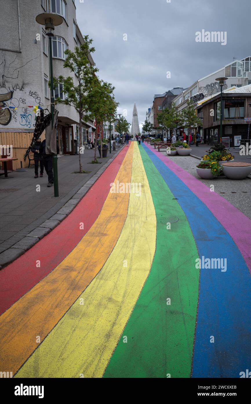 Reykjavik, Island - 15. Juli 2021 : pulsierende Regenbogenstraße in Reykjavik, die den Blick auf die berühmte Hallgrimskirkja Kirche in der Ferne zieht Stockfoto