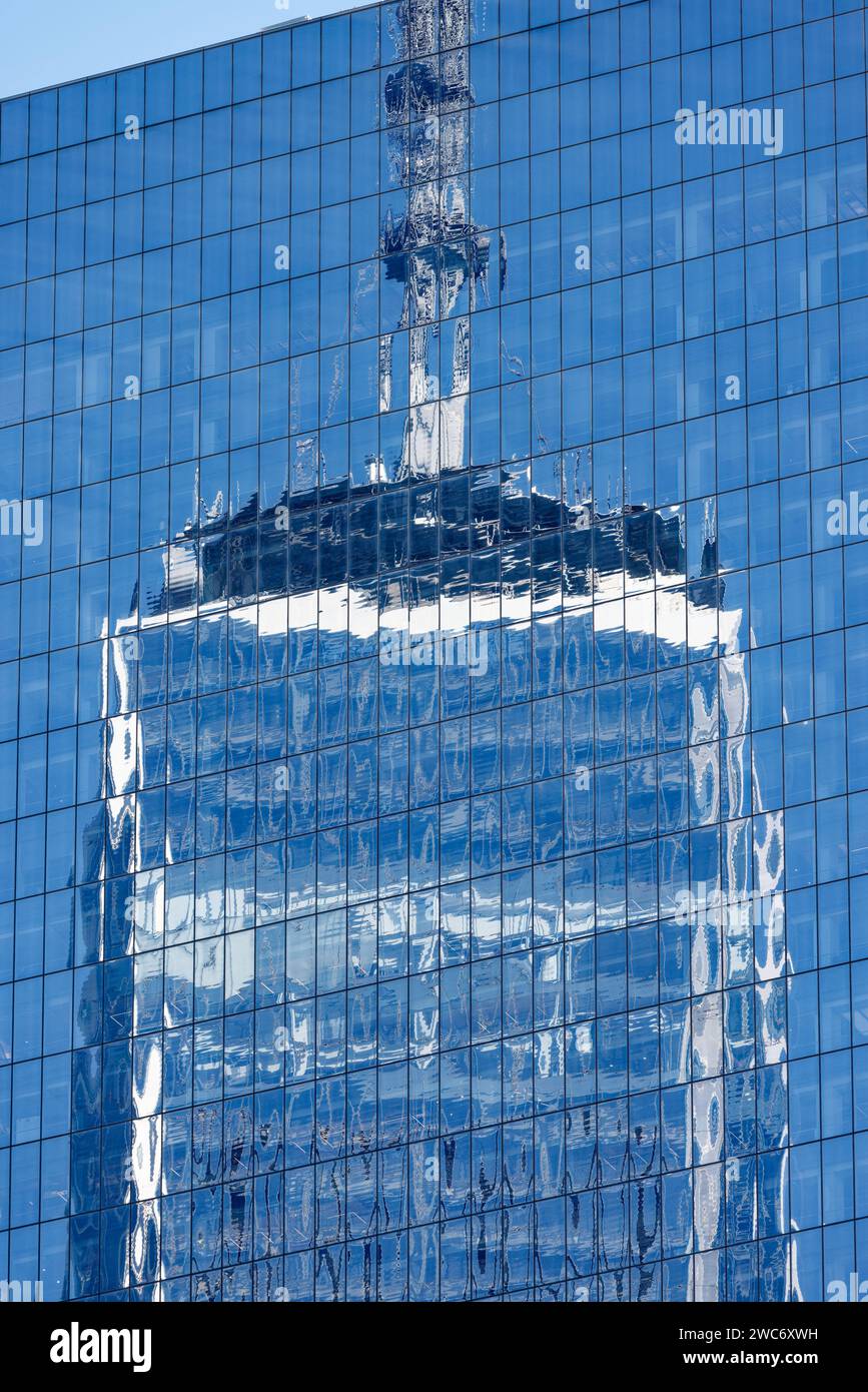 Die stark reflektierende Vorhangfassade des Four World Trade Center spiegelt seine Umgebung aus jedem Winkel wider, über dem dreifach hohen Glassockel. Stockfoto