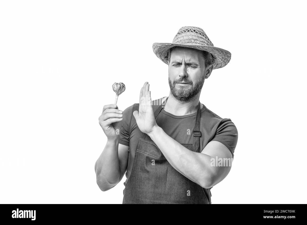 Mann in Schürze und Hut mit Knoblauch Gemüse isoliert auf weiß. Schlechter Geruch Stockfoto