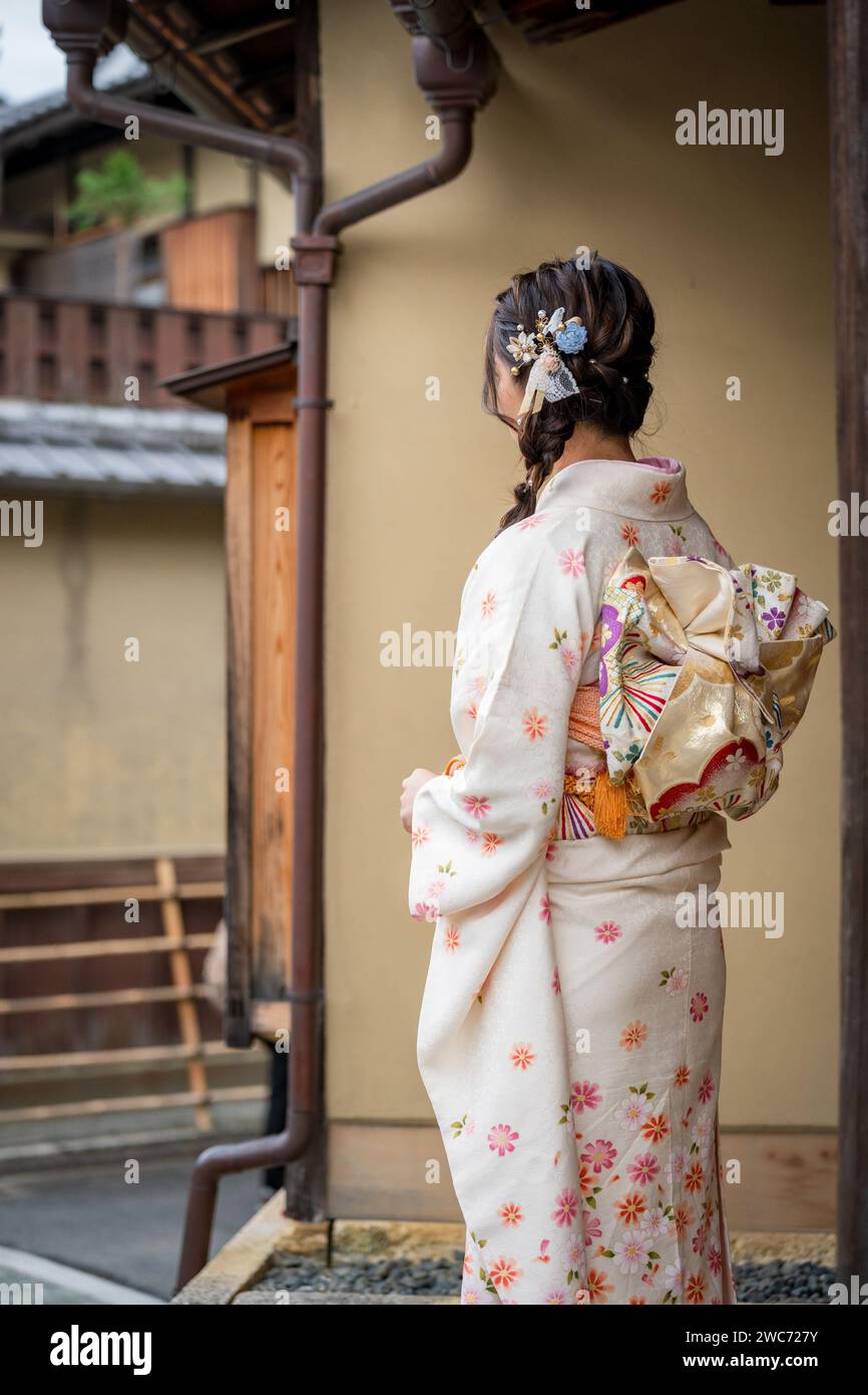 Japanische weibliche Kimono Porträt Rückansicht Fotografie. Kyoto, Japan. Traditionelle japanische Gebäude im Hintergrund. Stockfoto