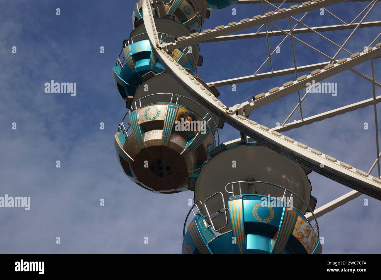 Gondeln und Speichen eines Riesenrades bei einem Stadtfest in Marburg im Oktober 2023 vor einem blau-weißen Himmel. Stockfoto