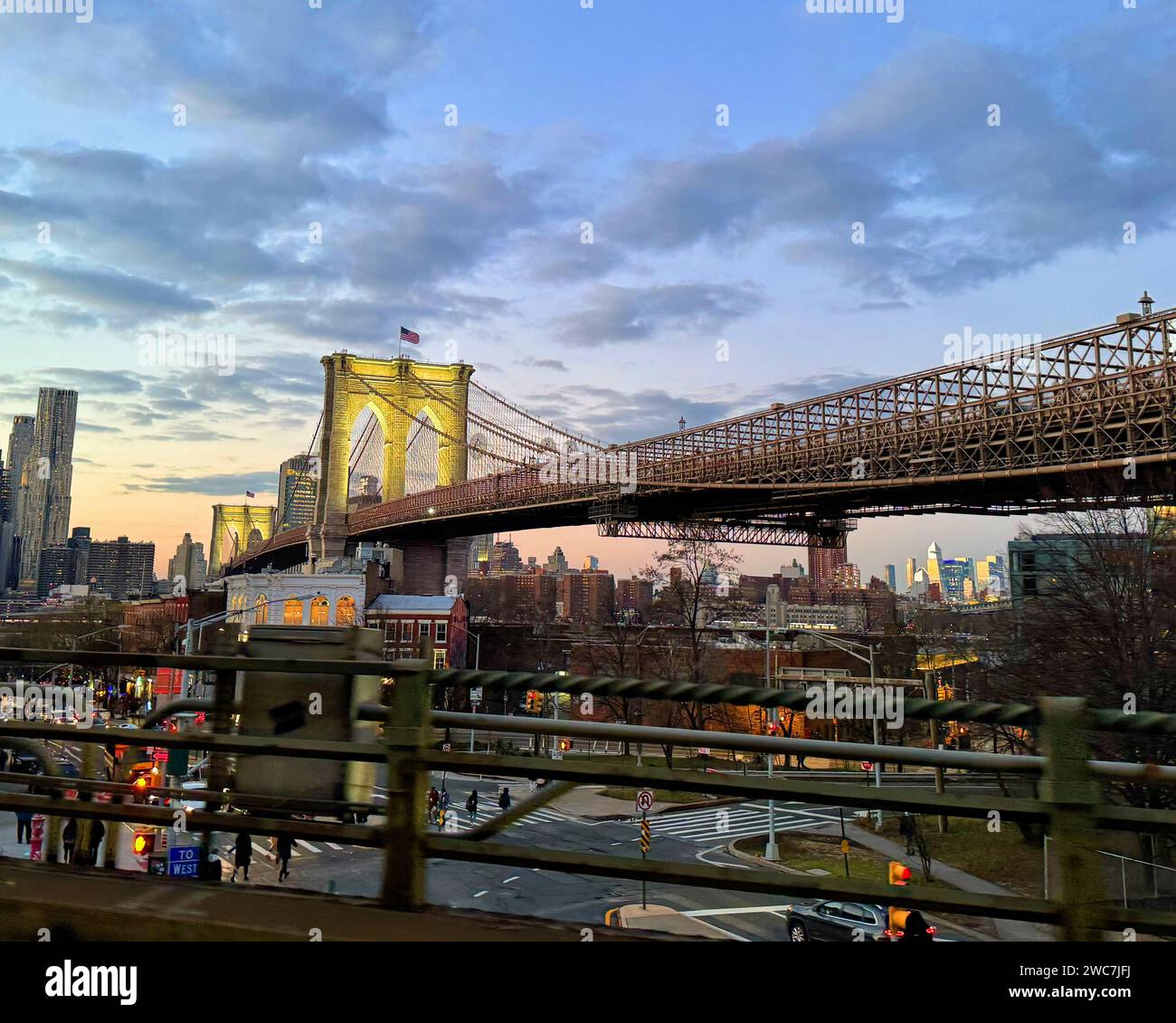 Dieses fesselnde Stockfoto erfasst die malerische Aussicht von der Rückseite eines Zuges, der anmutig die berühmte Brooklyn Bridge überquert Stockfoto