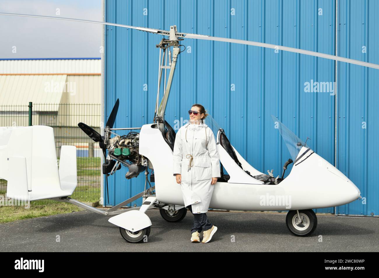 Eine Frau in der Nähe eines weißen Gyrocopters Stockfoto